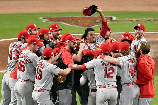 Cardinals relief pitcher Genesis Cabrera waves his hat in the air as he celebrates with teammates after Wednesday's 13-1 win against the Braves in Game 5 of their National League Divisional Series in Atlanta.