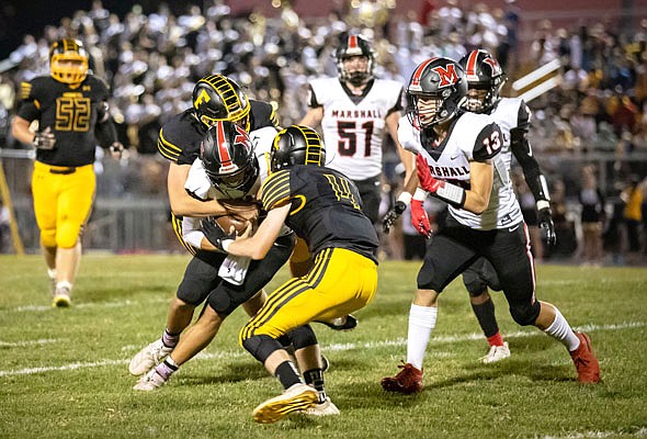 Fulton defensive back Will Privia (4) and a teammate partner up to take down a Marshall ball carrier during the Hornets' 48-8 North Central Missouri Conference loss to the Owls last month at Robert E. Fisher Stadium in Fulton.