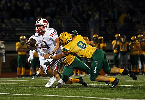 Jays quarterback Cole Gresham runs between Rock Bridge teammates Peyton Carr and David Gysbers (9) during last Friday night's game in Columbia. 