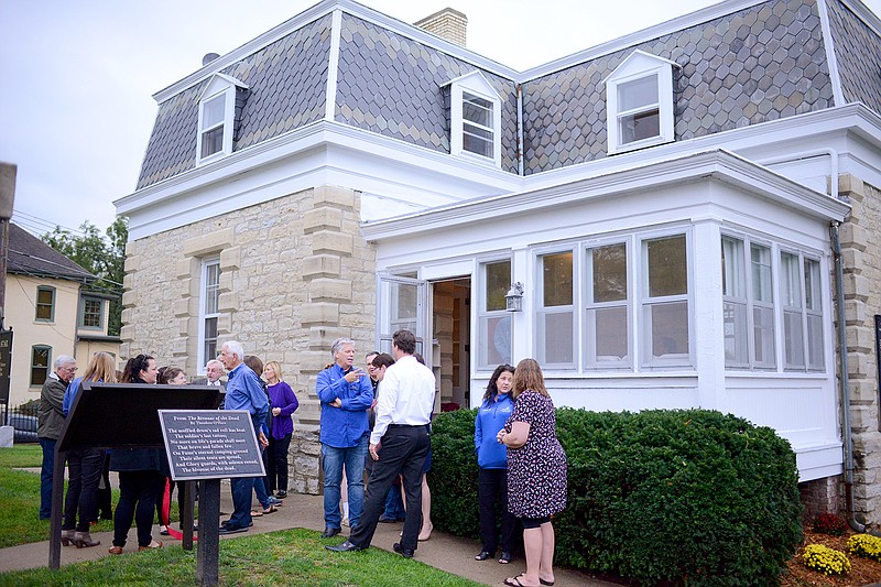 Guests stand outside the newly renovated caretaker's cottage Thursday during an open house at the Jefferson National Cemetery. The Historic City of Jefferson has partnered with the U.S. Department of Veterans Affairs to create office spaces in the building for veterans.