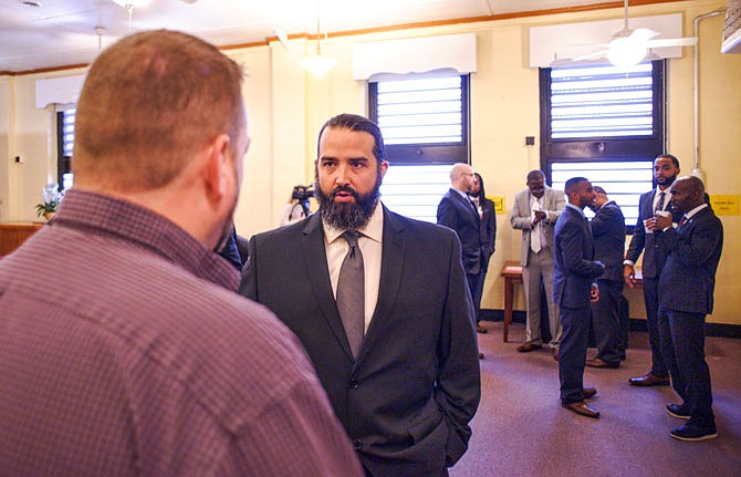 John Dawson III, center, speaks with Algoa Correctional Center Deputy Warden Scott Weber on Friday just before Dawson's graduation ceremony in a new re-entry program at the prison called Save Our Sons.