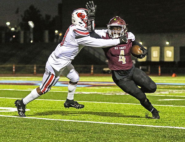 De Smet running back Darez Snider tries to break free from Jefferson City defensive back Devin White during Friday night's game in St. Louis.