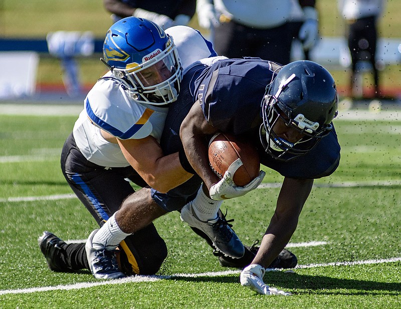 Lincoln wide receiver Rashaad Harris fights for extra yardage while being dragged to the turf by Nebraska-Kearney defensive back Blake Bubak during Saturday's game at Dwight T. Reed Stadium.