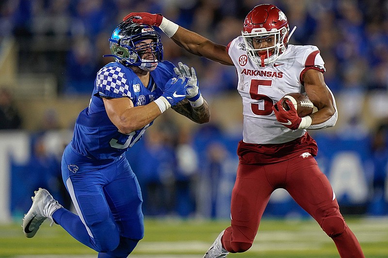 Arkansas running back Rakeem Boyd (5) runs with the ball as he is tackled by Kentucky linebacker Kash Daniel during the first half of an NCAA college football game Saturday, Oct. 12, 2019, in Lexington, Ky. (AP Photo/Bryan Woolston)
