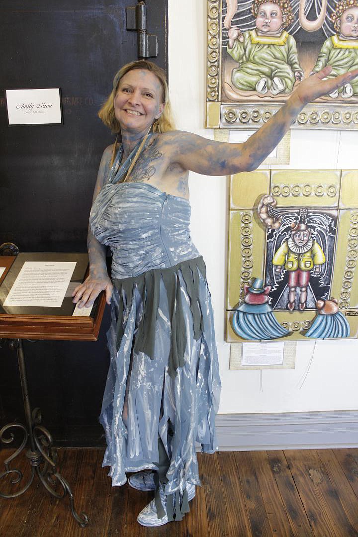 Amily Miori, also known as Phenomenal Anomaly Amily, poses with her work Saturday at the 1894 Gallery in downtown Texarkana. Her paintings highlight the roots of fairytales — when the stories were meant for adults, not children. 