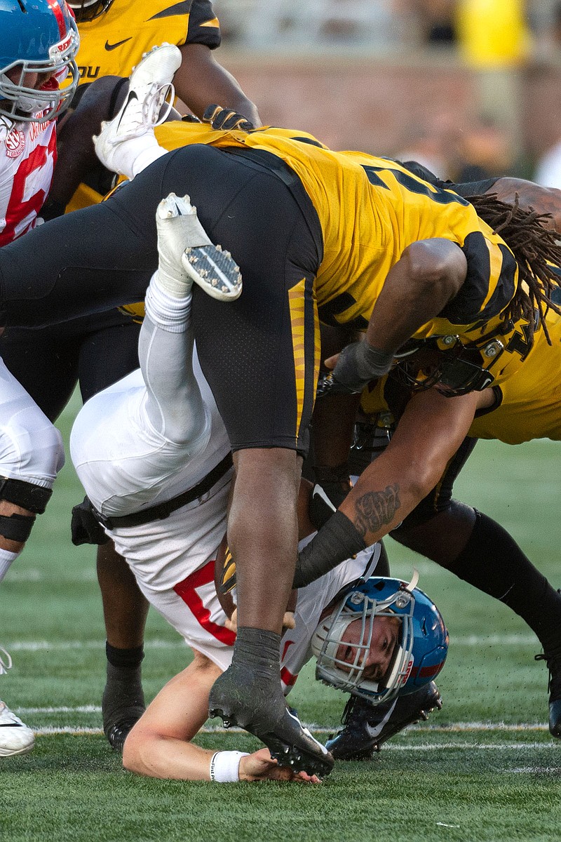 Mississippi quarterback John Rhys Plumlee is turned upside down as he is tackled by Missouri linebacker Nick Bolton during the first quarter of Saturday's game at Faurot Field. 