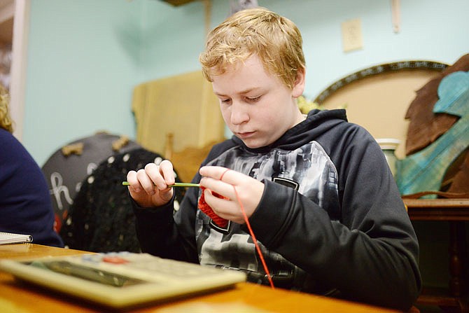 Jude Wildhaber, 14, crochets a soap holder Saturday during a Young Entrepreneur Market at J Street Vintage. Wildhaber has been crocheting since he was 8 years old. 