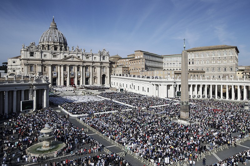 Faithful gather in St. Peter's Square at the Vatican, Sunday, Oct. 13, 2019. Pope Francis on Sunday canonized Cardinal John Henry Newman, the 19th-century Anglican convert who became an immensely influential, unifying figure in both the Anglican and Catholic churches. Francis presided over Mass on Sunday in a packed St. Peter's Square to declare Newman and four women saints. (AP Photo/Alessandra Tarantino)