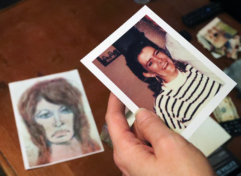 In this Thursday, Oct. 10, 2019 photo, Tonya Maslar holds an old photograph of her mother Roberta Tandarich taken before her death in 1991 in Ravenna, Ohio. Tandarich's body was found dumped at Firestone Metro Park in 1991. A sketch of Tandarich drawn by serial killer Samuel Little, who claims Tandarich was one of his many victims, lies in the background. (Jeff Lange/Akron Beacon Journal via AP)