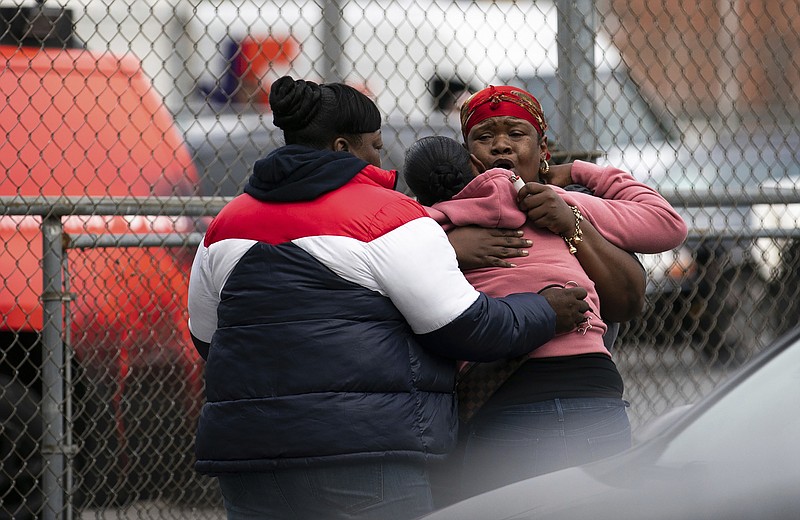 People embrace at the scene of a shooting in the Brooklyn borough of New York on Saturday, Oct. 12, 2019. Police were investigating Sunday whether a gambling dispute, robbery or something else led to the shooting deaths of several people at an illegal gambling club in Brooklyn that was just blocks from a police precinct. (AP Photo/Jeenah Moon)