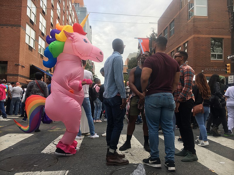 A person in a unicorn costume walks among others in attendance at Philadelphia OutFest, Sunday, Oct. 13, 2019, in Philadelphia. National Coming Out Day festivities were tempered this year by anxiety over Supreme Court arguments that will decide whether the Civil Rights Act covers workplace discrimination based on sexual orientation and gender identity. (AP Photo/Jeff McMillan)