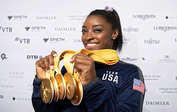 Simone Biles of the United States shows her five gold medals she won at the Gymnastics World Championships on Sunday in Stuttgart, Germany.