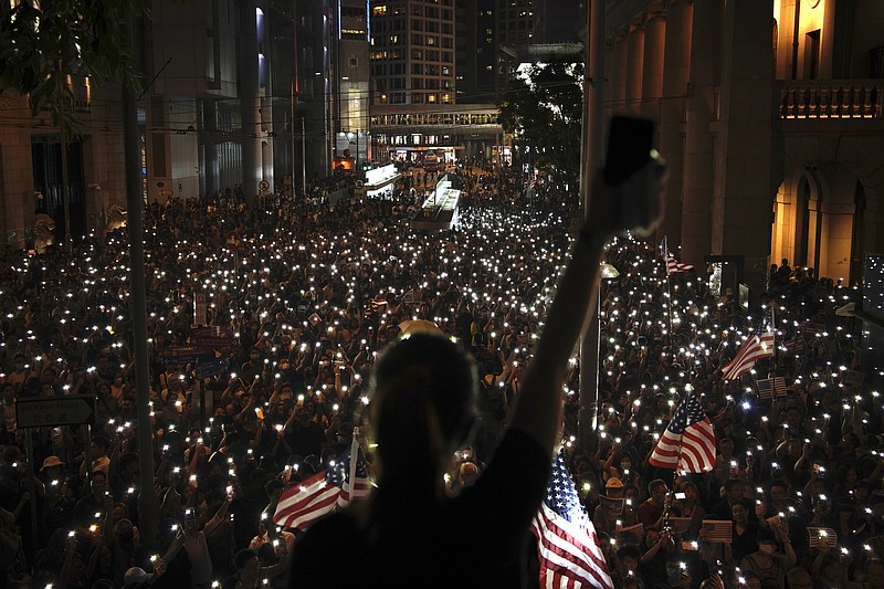Protestors light their torches during a peaceful rally in central Hong Kong's business district, Monday, Oct. 14, 2019. The protests that started in June over a now-shelved extradition bill have since snowballed into an anti-China campaign amid anger over what many view as Beijing's interference in Hong Kong's autonomy that was granted when the former British colony returned to Chinese rule in 1997. (AP Photo/Felipe Dana)