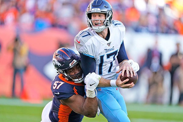 Broncos defensive end DeMarcus Walker hauls down Titans quarterback Ryan Tannehill during the second half of Sunday's game in Denver.