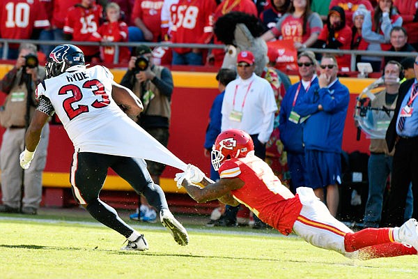 Chiefs cornerback Bashaud Breeland hangs on to the jersey of Texans running back Carlos Hyde during the second half of Sunday afternoon's game at Arrowhead Stadium.