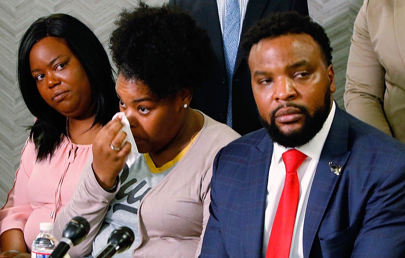  Amber Carr wipes a tear as her sister, Ashley Carr, left, and attorney Lee Merritt, right, listen to their brother Adarius Carr talk about their sister, Atatiana Jefferson, during a news conference Monday in Dallas. Jefferson, 28, was shot and killed by Officer Aaron Dean on Saturday in her home as she played video games with her 8-year-old nephew. 