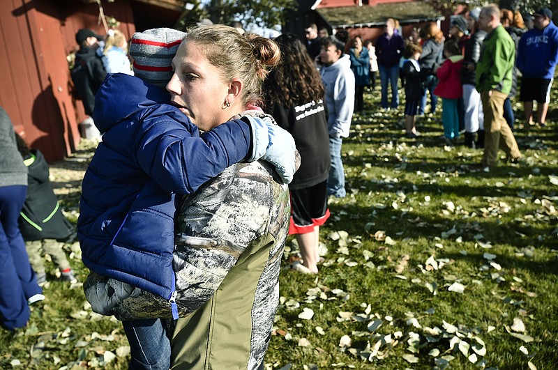 Marnie Wedgwood hugs her son after an improvised explosive device detonated on the Rossiter Elementary school playground Tuesday, Oct. 15, 2019, in Helena, Mont. Students were evacuated and then reunited with their parents at a separate location from the school. (Thom Bridge/Independent Record via AP)