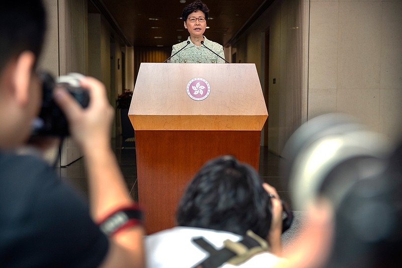 Journalists take photos as Hong Kong Chief Executive Carrie Lam speaks during a press conference at the government building in Hong Kong, Tuesday, Oct. 15, 2019. A homemade, remote-controlled bomb intended to "kill or to harm" riot control officers was detonated as they deployed against renewed violence in Hong Kong over the weekend, police said Monday, in a further escalation of destructive street battles gripping the business hub. (AP Photo/Mark Schiefelbein)