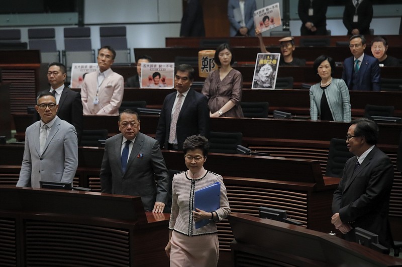 Hong Kong Chief Executive Carrie Lam, center, walks into Legislative Council in Hong Kong Wednesday, Oct. 16, 2019. In chaotic scenes, furious pro-democracy lawmakers twice forced Hong Kong's leader to stop delivering a speech laying out her policy objectives and clamored for her to resign after she walked out of the legislature on Wednesday and then delivered the annual address 75 minutes late via television. (AP Photo/Kin Cheung)
