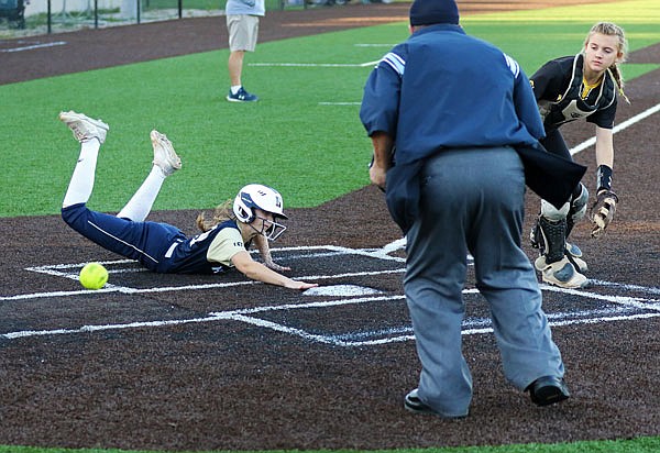 Livia Bloomer of Helias scores as Fulton catcher Rylee Flynn Baker chases after the ball during Thursday's Class 3 District 9 Tournament semifinal game in Ashland.