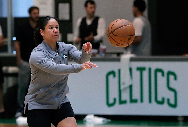 In this July 1, 2019, file photo, Boston Celtics assistant coach Kara Lawson passes the ball at the team's training facility in Boston. Celtics guard Gordon Hayward said Lawson has already made her presence felt. "She's been good as far as just the experience she has as a basketball player," Hayward said. "Reading the game and kind of little things she sees coaching on the sideline. Having somebody that well-versed in basketball, that experience is good." (AP Photo/Charles Krupa, File)