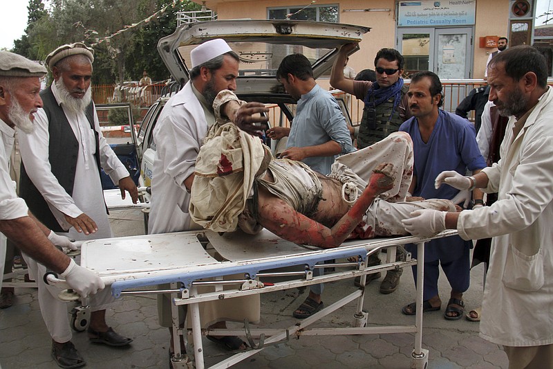 A wounded man is brought by stretcher into a hospital after a mortar was fired by insurgents in Haskamena district of Jalalabad east of Kabul, Afghanistan, Friday, Oct. 18, 2019. An Afghan official says at least several people have been killed during Friday prayers when a mortar fired by insurgents blasted through the roof of a mosque. (AP Photo/Wali Sabawoon)