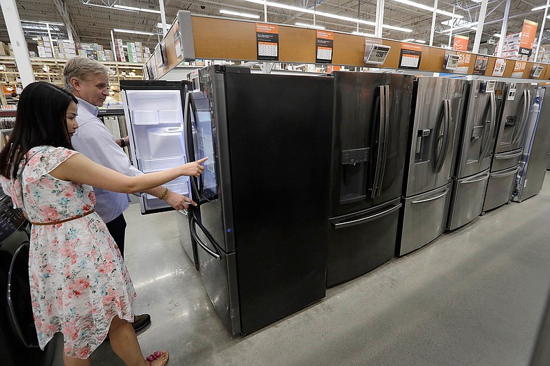 In this Sept. 23, 2019, photo shoppers examine refrigerators at a Home Depot store location, in Boston. On Wednesday, Oct. 16, the Commerce Department releases U.S. retail sales data for September. (AP Photo/Steven Senne)