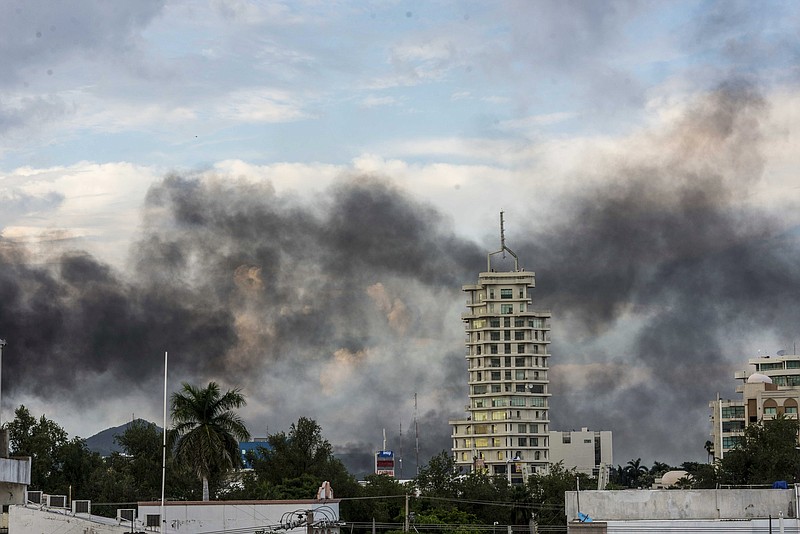 This Oct. 17, 2019 photo shows clouds of smoke from burning cars mar the skyline of Culiacan, Mexico. The Mexican city lived under drug cartel terror for 12 hours as gang members forced the government to free a drug lord. (AP Photo/Hector Parra)