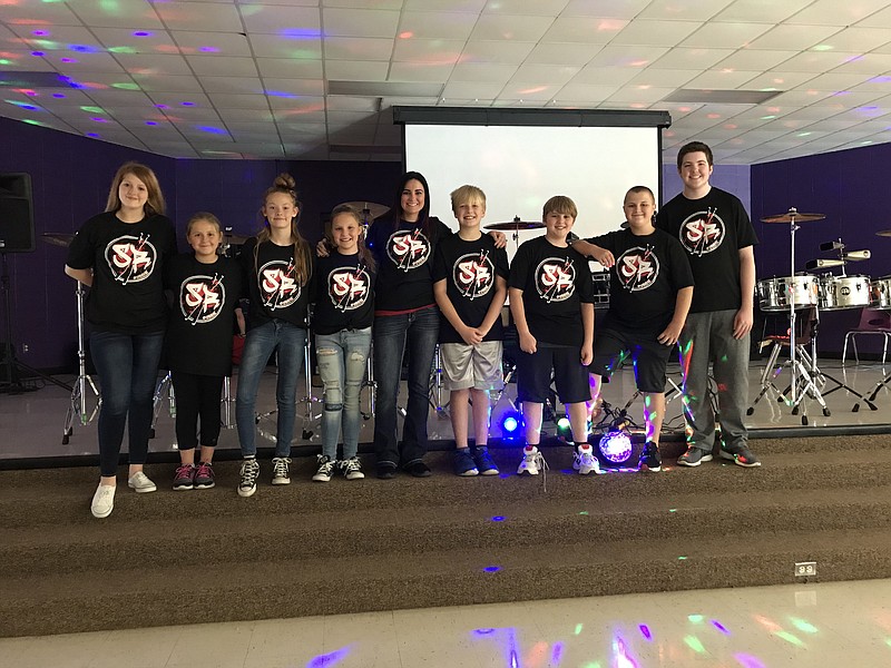 Members of the Sheltered Reality Drumline gather for a photo following a recent performance.