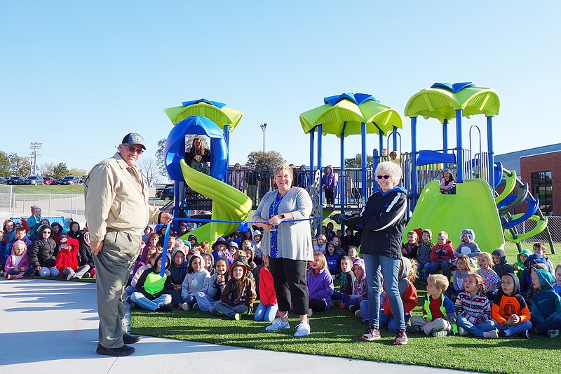 Students at South Callaway Middle School clamber onto the new playground equipment Tuesday during a ribbon-cutting ceremony. Retired teacher Donna McGrath, right, helped kick off the playground updates by encouraging her fifth-graders to write letters to administrators.