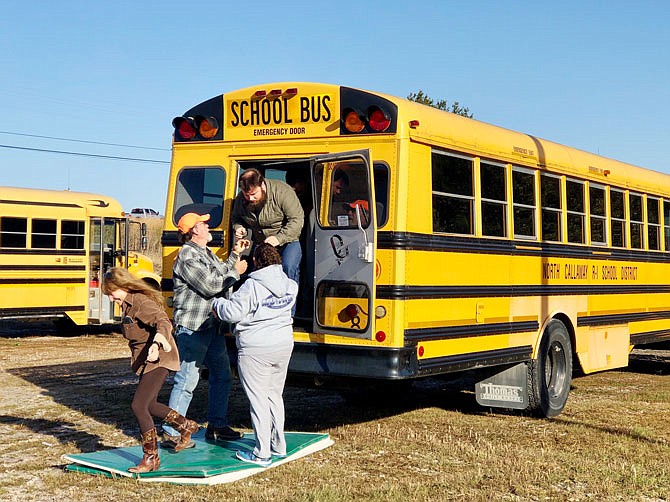 Participants in the National School Bus Safety Week training Monday at the North Callaway Transportation Facility practice rapid evacuation techniques. These techniques could save lives in the event of a fiery crash or other malfunction.