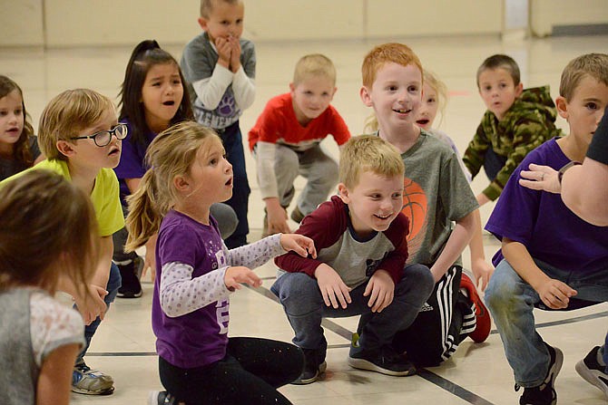Students slowly rise to their feet as they sing together Friday during a dance party at Callaway Hills Elementary School. Students received rewards such as backpacks, T-shirts, and participation in a kickball game, dance party or bounce house after they collected pledges to raise money in the parent-teacher organization's fun run. 