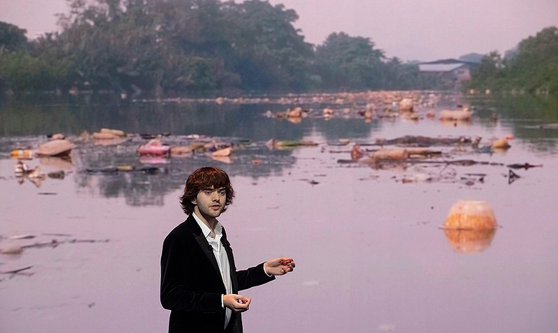 Young Dutch inventor Boyan Slat presents his plans for the Interceptor, a plastic-gathering floating device, in front of a video of a polluted river, during a presentation in Rotterdam, Netherlands, Saturday, Oct. 26, 2019. Slat is taking his effort to clean up floating plastic from the Pacific Ocean to rivers to catch garbage before it reaches the seas. (AP Photo/Peter Dejong)