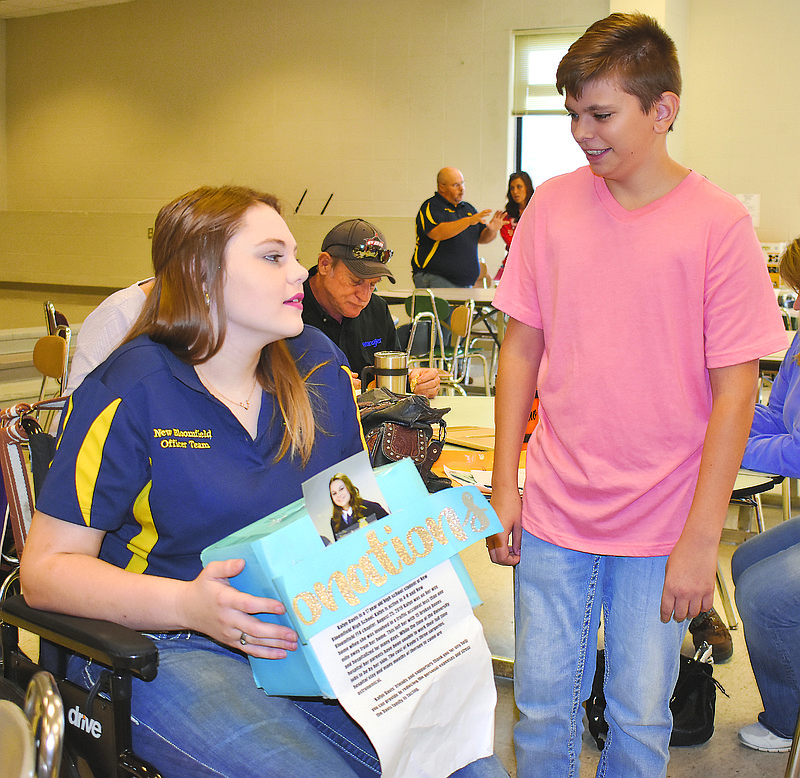 Braden Kliethermes, right, gives Kayln Davis a box containing donations from a car wash to help pay for Davis' medical bills from a recent vehicle accident. The two New Bloomfield FFA members were at the annual FFA barbecue fundraiser Sunday, which also featured live and silent auctions to benefit Davis. 