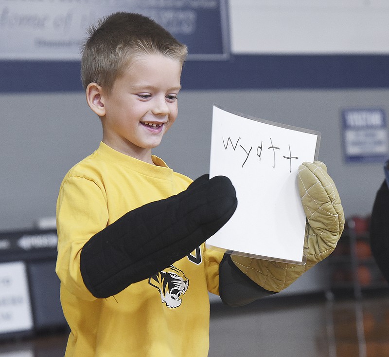 After printing his name using his weighted and oven mitt clad non-dominant hand, Wyatt Slaughter stood up to show his fellow students that he was able to complete the task. 