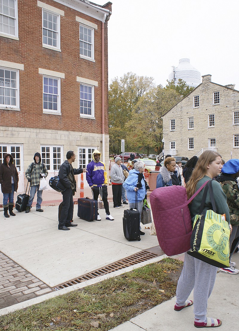 Amtrak passengers wait outside the station Tuesday morning as they prepare to catch the eastbound train to St. Louis. The Union Hotel, which houses the local Amtrak station, has been closed for nearly a month due to structural problems.