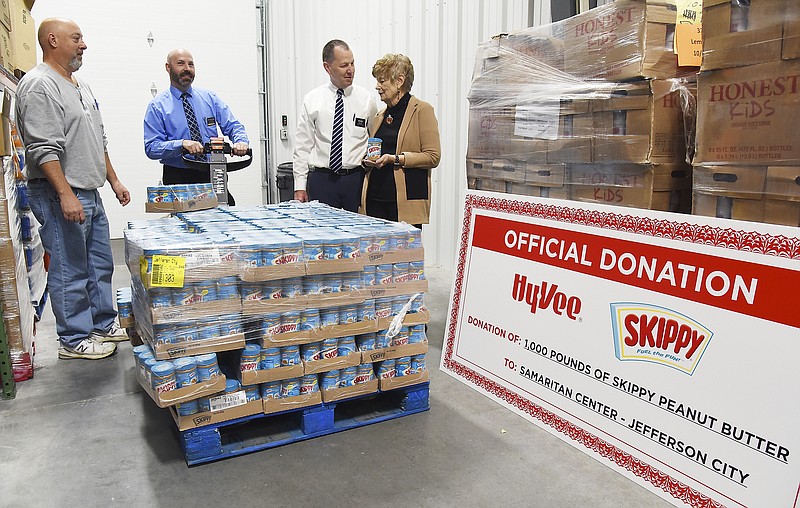 Jefferson City Hy-Vee Store Director Rod Dolph, second from right, explains to Marylyn DeFeo the 1,000 pounds of peanut butter on the pallet should be enough to make more than 16,000 sandwiches. DeFeo is executive director of the Samaritan Center and, along with food pantry manager Carlos Robinett, at left, accepted delivery of the pantry staple. Second from left is Donovan Sigwerth, assistant director of Hy-Vee. The peanut butter was made available through Hormel Foods' Spread the Smiles campaign.