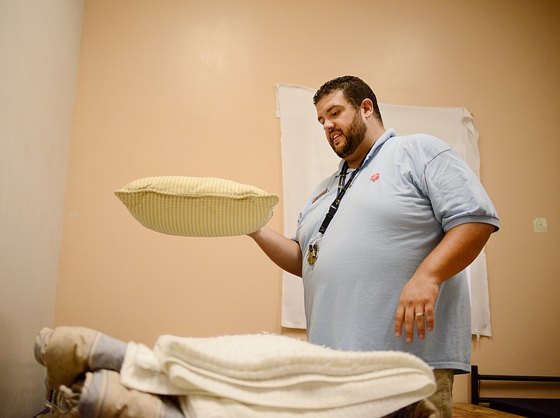 Director Brian Vogeler places clean pillows and blankets onto a bed Tuesday, Oct. 2, 2019, at the Salvation Army Center of Hope in Jefferson City.
