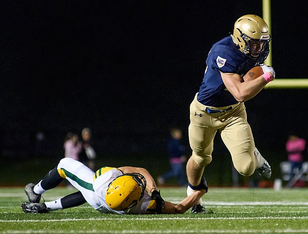 Jake Warren of Helias fights through a tackle attempt by Rock Bridge cornerback Jackson McFadden after making a catch in the flat during a game last month at Ray Hentges Stadium.