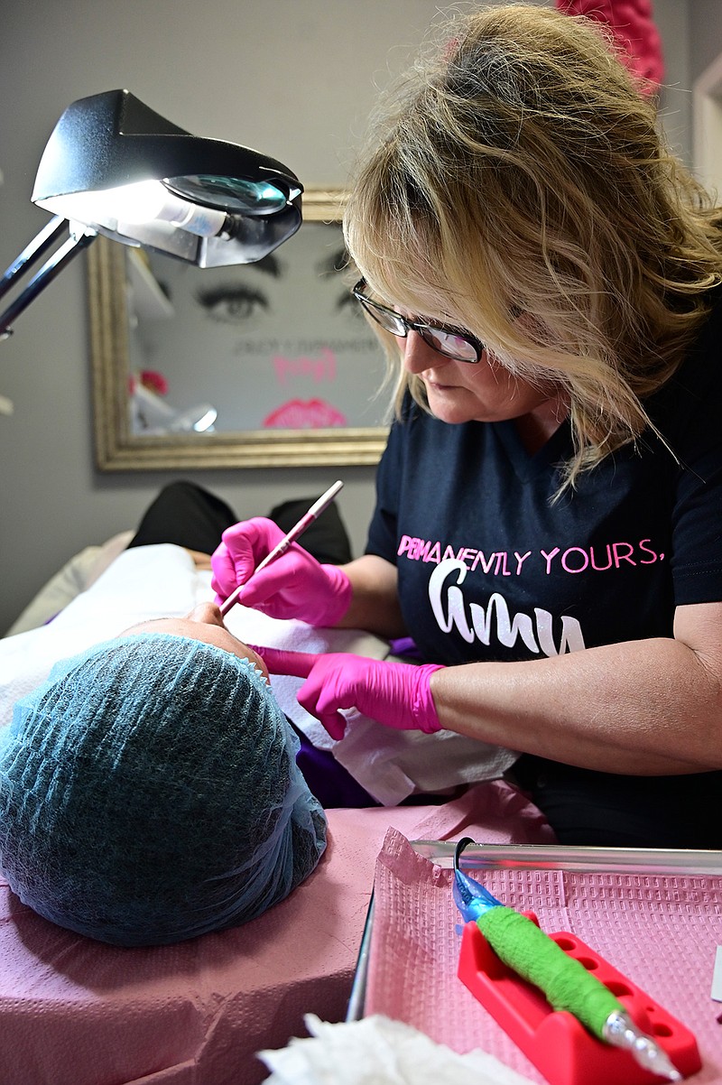 Permanent make-up artist Amy Yancy applies lip-liner to her client before a session at Sheer Image Salon in Texarkana, Texas. 
