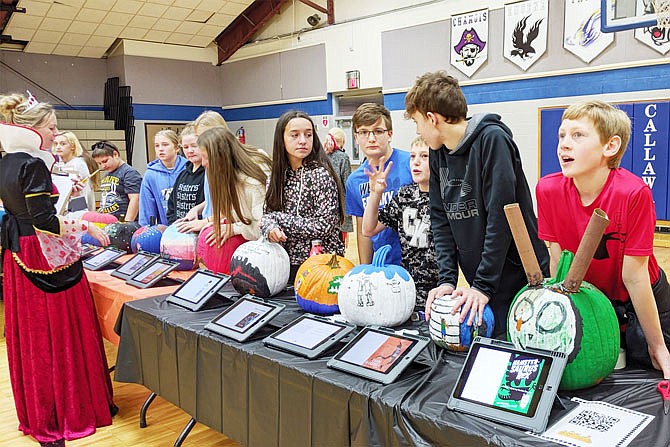 Seventh-grade students at South Callaway Middle School turned their book reports into pumpkins and interactive slideshows. Teacher Heather Fees, left, said the project lets children show their creativity.