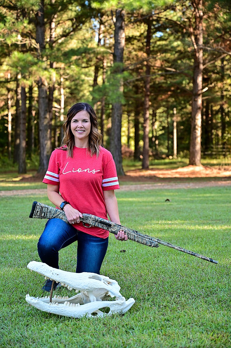 Liz Bowman poses for a portrait in her Horatio, Ark., front yard with the shotgun used to killed a 12-foot alligator in September. 
