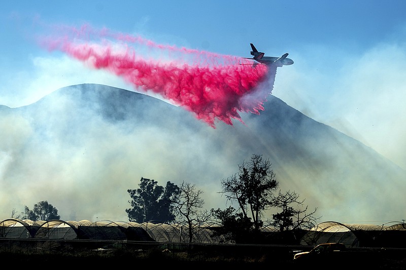 An air tanker drops retardant as the Maria Fire approaches Santa Paula, Calif., on Friday, Nov. 1, 2019. According to Ventura County Fire Department, the blaze has scorched more than 8,000 acres and destroyed at least two structures. (AP Photo/Noah Berger)