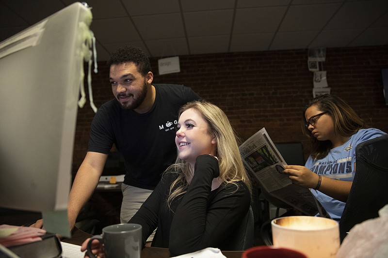 This Oct. 29, 2019 photo shows Editor-in-Chief Maddy Arrowood, a senior journalism and American history major, center,   Copy Chief Brandon Standley, a junior advertising and psychology major, left, and Photo Co-Editor Maya Carter, a senior psychology and English major, at the office of The Daily Tar Heel, the independent student newspaper of the University of North Carolina in Chapel Hill, N.C. Thousands of young journalists train for the future on a dual track, in classrooms and in student-run newsrooms that are models for the places they hope to work someday. (Dustin Duong/The Daily Tar Heel via AP)