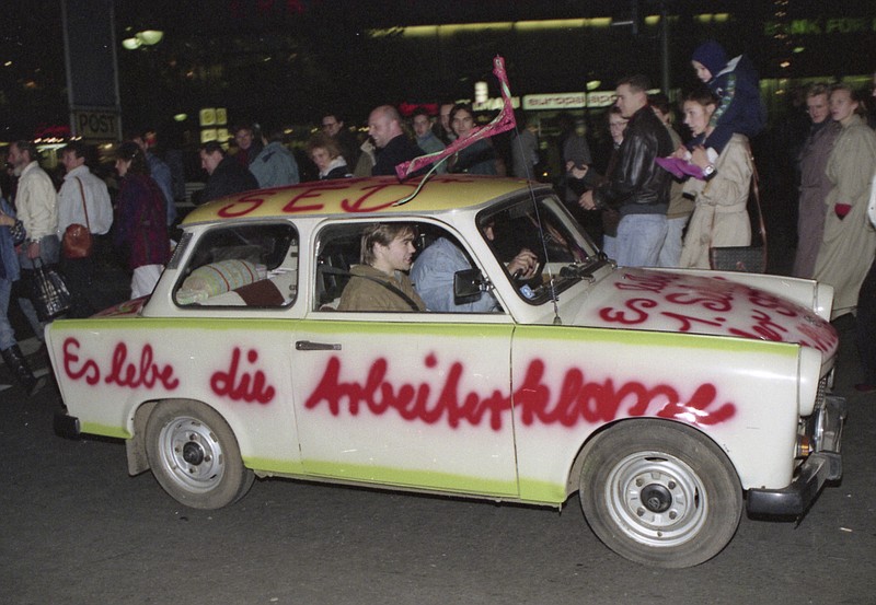 FILE - In this Nov. 11, 1989, file photo a Trabant car, made in East Germany, with a graffiti slogan 'Es lebe die Arbeiterklasse' (Shall the laboring classes live on) is pictured driving in West Berlin, Germany, two days after the boarder between the two Germanys was abolished. The abrupt fall of the Wall in 1989 and lightning speed that reunification took place took everyone by surprise at the time and was a shock to the system for some 16 million East Germans. Unrealistic expectations combined with other factors have helped lead to today’s discontent, providing fertile ground for the far-right. (AP Photo/File)