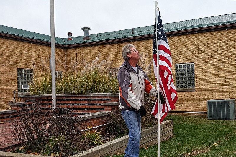 Pat Doty, a Fulton VFW volunteer, puts out flags ahead of Veterans Day. Two of his sons serve in the Armed Forces, he said.