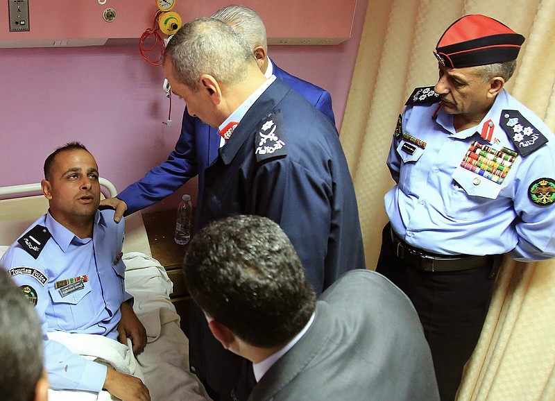 Royal Court chief Yousef Issawi, right, visits one of the victims of a knife attack in Jeraash,  Jordan on Wednesday, Nov. 6, 2019.  A young man from a Palestinian refugee camp on Wednesday stabbed eight people, including four foreign tourists and their tour guide, at a popular archaeological site in Jeraash, in northern Jordan, security officials said.  The wounded included three Mexican tourists and a Swiss woman, according to Jordan's Public Security office. Along with the tour guide, three other Jordanians, including two security officers and a bus driver, were also hurt before the attacker was subdued and arrested. (AP Photo/Raad Adayleh)