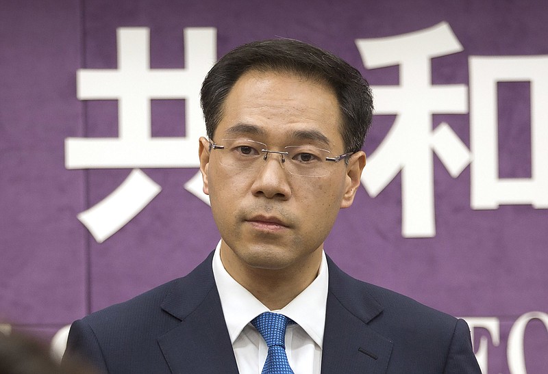 FILE - In this March 29, 2018, file photo, Chinese Ministry of Commerce spokesman Gao Feng listens to a reporter's question during a press conference at the Ministry of Commerce in Beijing. On Thursday, Nov. 7, 2019, China's Commerce Ministry says Washington and Beijing have agreed to cancel tariff hikes as their trade negotiations progress. (AP Photo/Mark Schiefelbein, File)