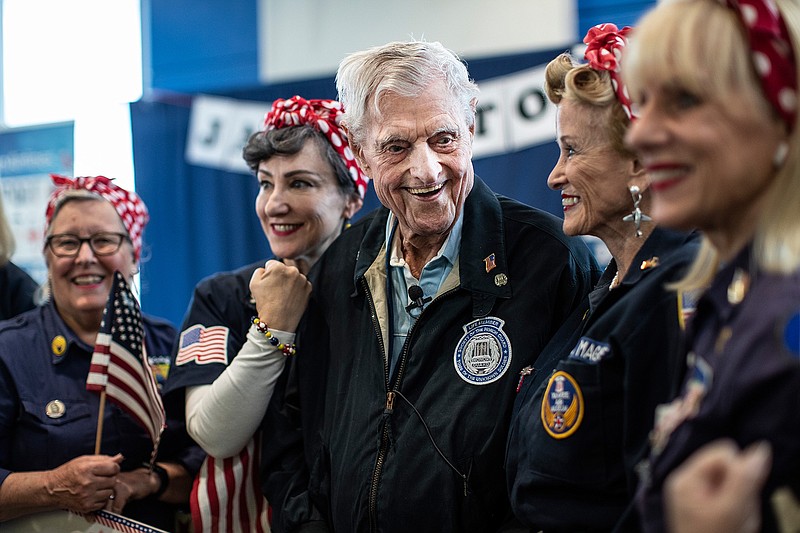 Jack Eaton, 100, the oldest living sentinel of the Tomb of the Unknown Soldier, laughs with Willow Run Tribute Rosie the Riveters as they pose for a photo at the Detroit Metropolitan Airport in Romulus, Wednesday, Oct. 23, 2019.  (Junfu Han/Detroit Free Press via AP)