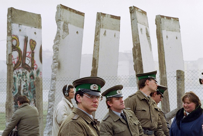 In this Nov. 13, 1989, file photo, East German border guards stand in front of segments of the Berlin Wall, which were removed to open the wall at Potsdamer Platz passage in Berlin. Months before the Berlin Wall fell on Nov. 9, 1989, with the Soviet stranglehold over the Eastern Bloc crumbling, a young political scientist named Francis Fukuyama made a declaration that quickly became famous. It was, he declared, "the end of history." (AP Photo/John Gaps III, File)